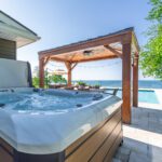 This is an example of Dream BNB Hospitality luxury rental property with essential vacation rental amenities including a hydrotherapy spa hot tub; pergola covered outdoor dining set, saltwater pool; panoramic Lake Erie Waterfront view.