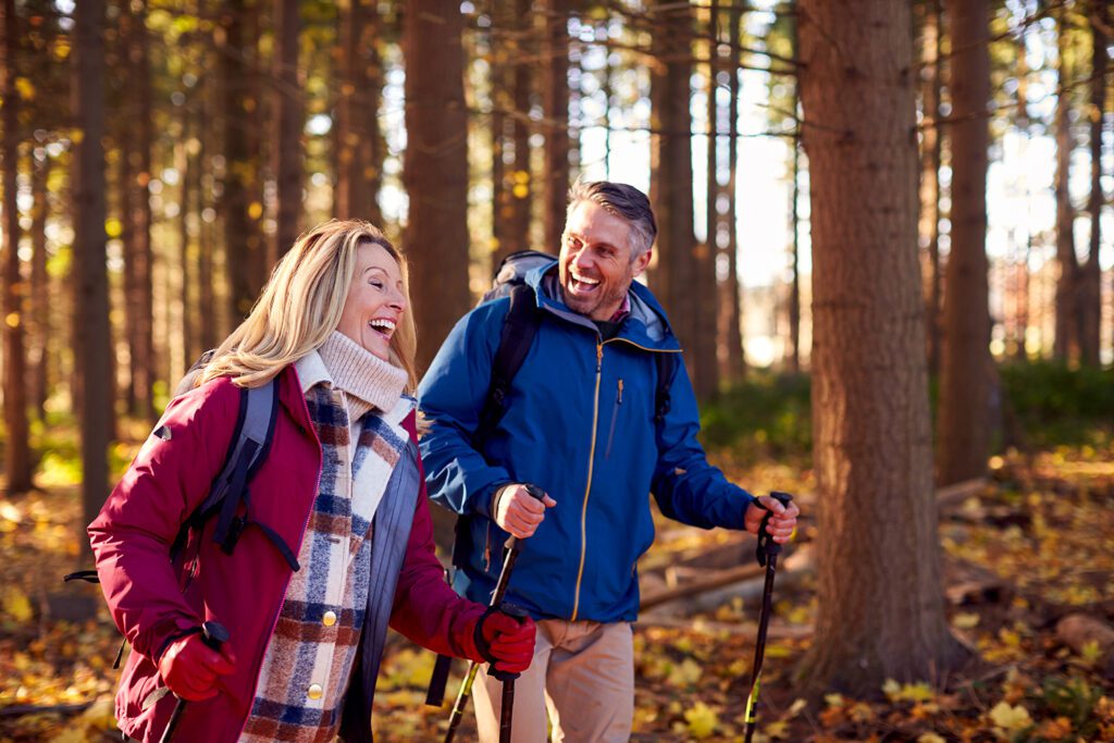 A happy couple hiking in a forest.