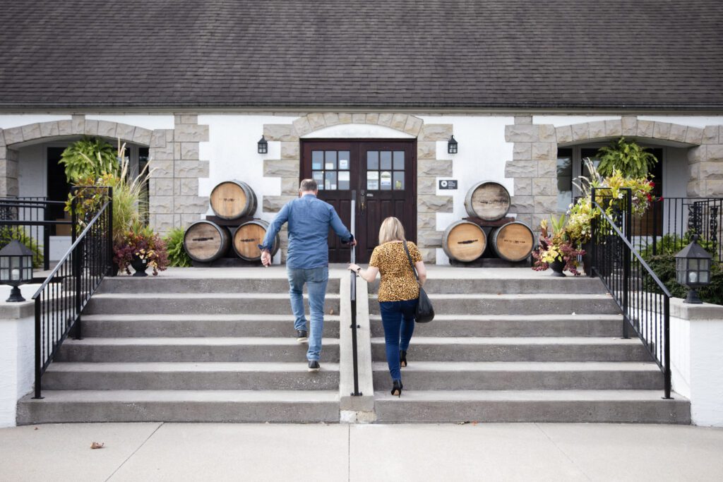 A man and woman walking up the steps to the main entrance of Pelee Island Winery in Kingsville, Ontario. 