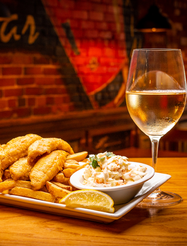 Fish and chip dinner and a glass of white wine as served at Crave Family Grill